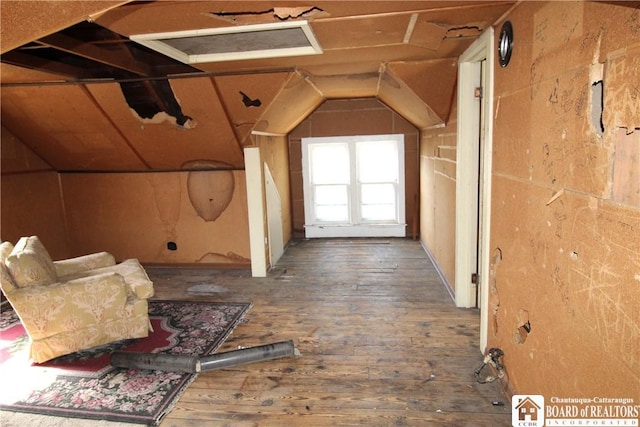 hall featuring wood-type flooring and vaulted ceiling