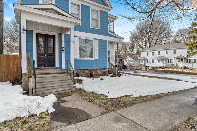 view of exterior entry with a residential view and fence