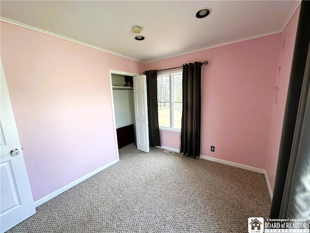 unfurnished bedroom with visible vents, baseboards, ornamental molding, a closet, and carpet flooring