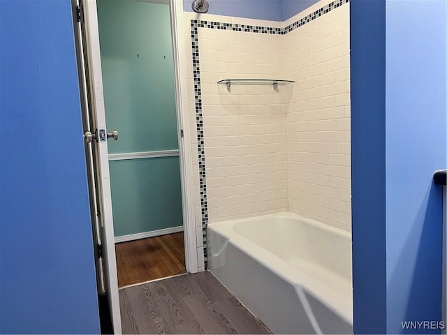 full bath featuring shower / bath combination, baseboards, and wood finished floors