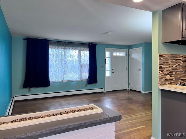 entrance foyer with baseboards, baseboard heating, and wood finished floors