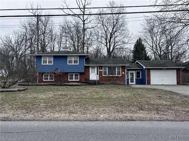 split level home featuring brick siding, driveway, a front yard, and a garage