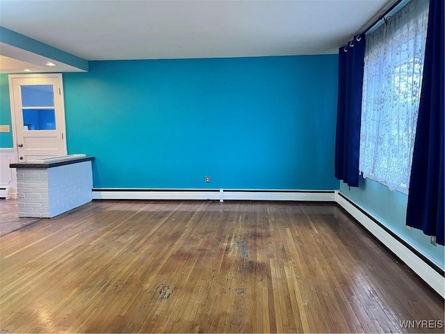 spare room with hardwood / wood-style floors and a baseboard radiator