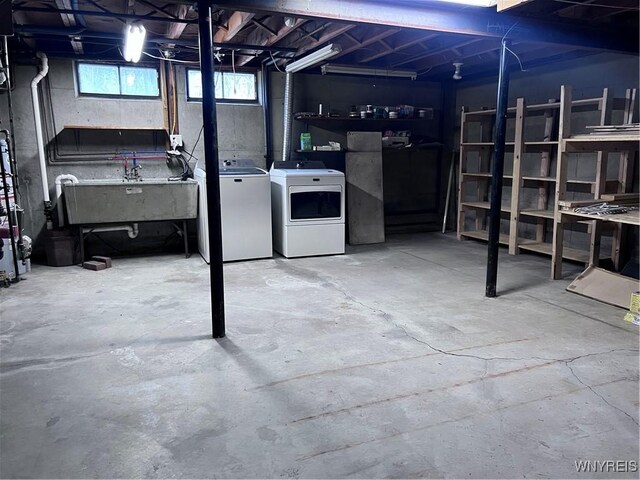 basement featuring separate washer and dryer and a sink