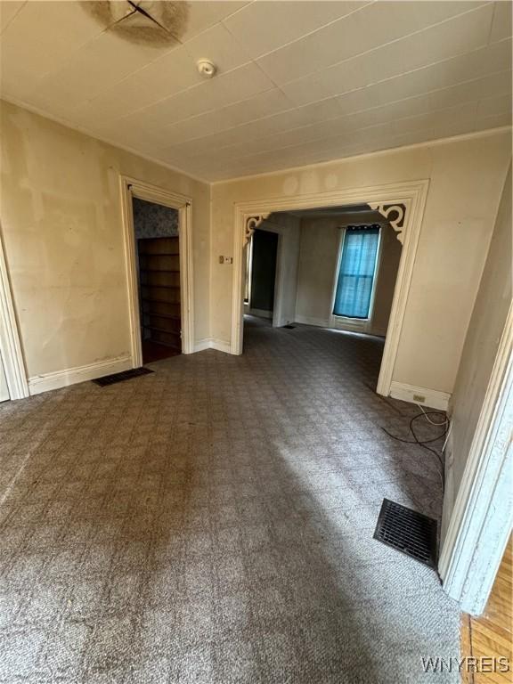 spare room with baseboards and visible vents