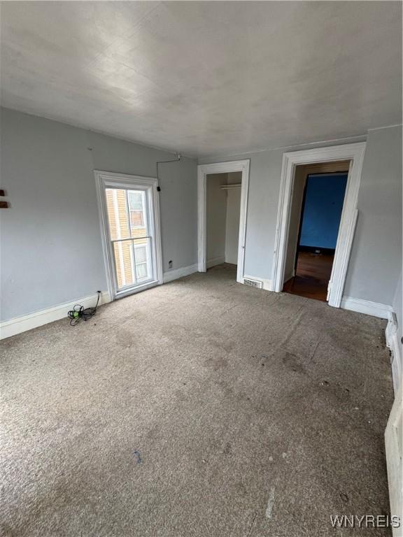 unfurnished room with baseboards and carpet floors