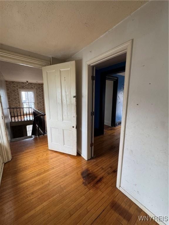 spare room with a textured ceiling and light wood finished floors