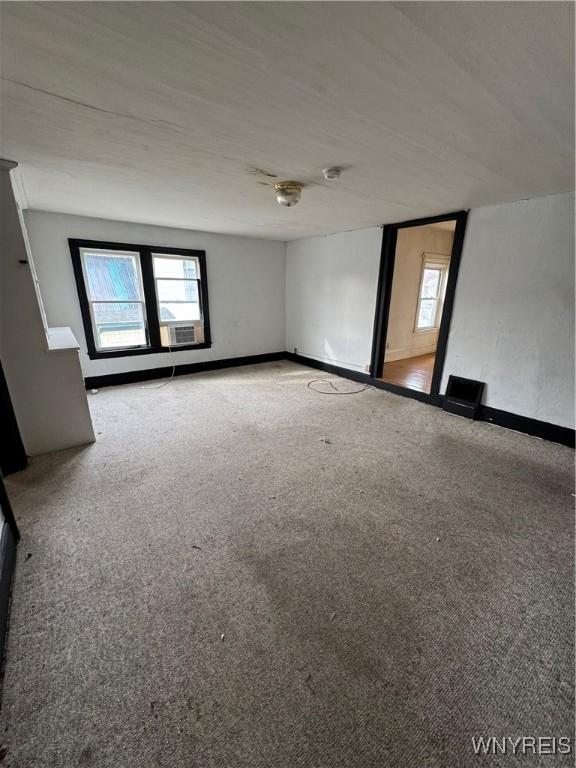 spare room with plenty of natural light, baseboards, and carpet floors