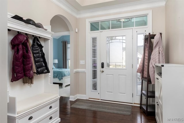 foyer with arched walkways, dark wood-type flooring, and crown molding