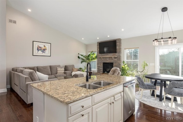 kitchen featuring visible vents, a sink, vaulted ceiling, stainless steel dishwasher, and open floor plan