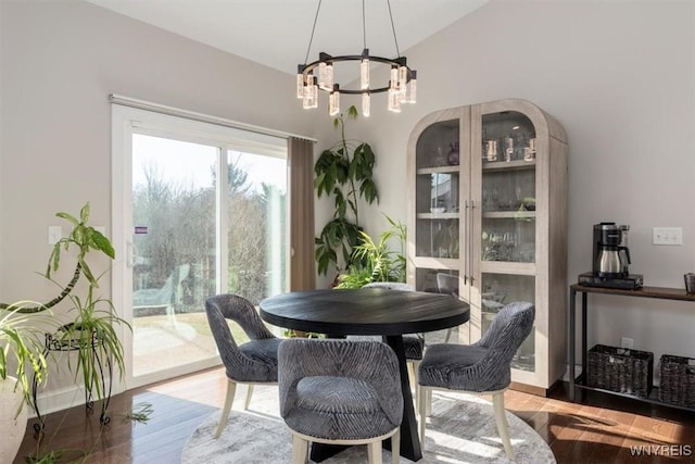 dining space with an inviting chandelier, wood finished floors, and baseboards