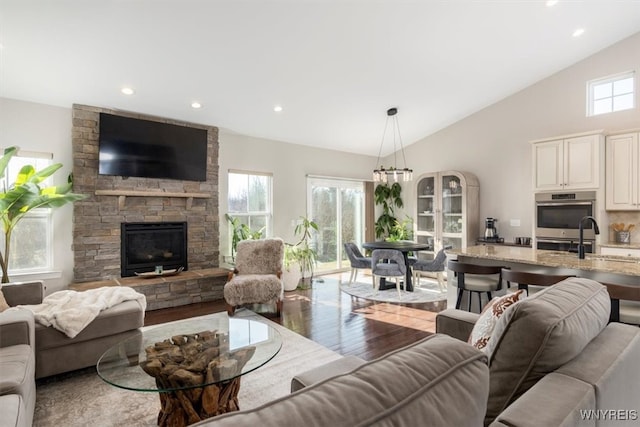 living room featuring recessed lighting, plenty of natural light, wood finished floors, and a fireplace