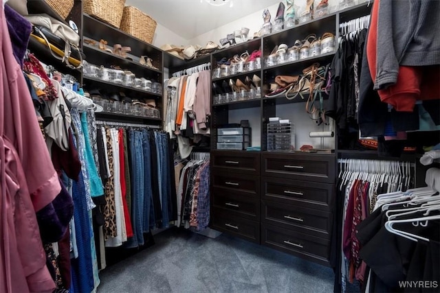 walk in closet featuring dark colored carpet