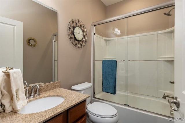 full bath with vanity, toilet, and combined bath / shower with glass door