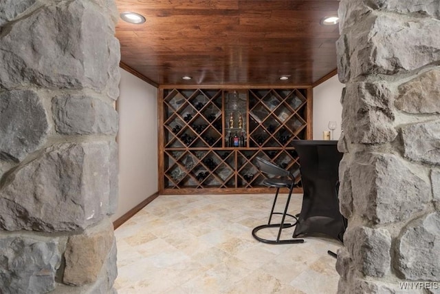 wine cellar with crown molding, recessed lighting, wood ceiling, and baseboards