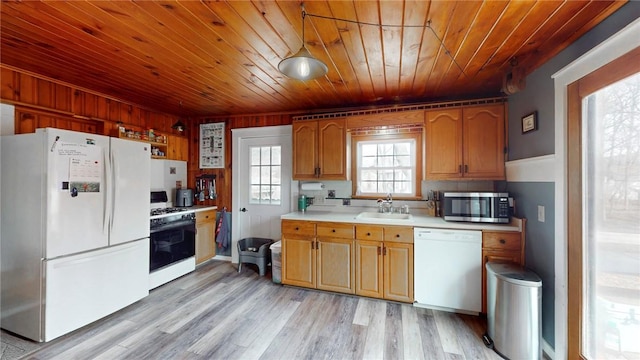 kitchen featuring white appliances, a sink, light countertops, light wood-style floors, and wooden ceiling