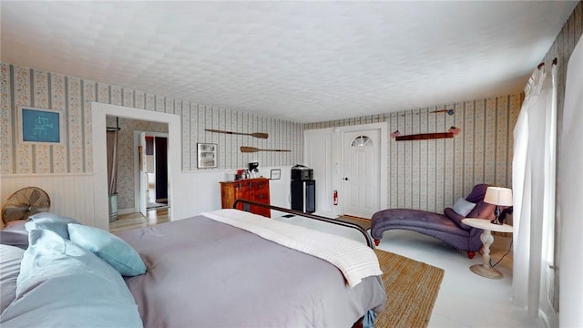 bedroom with a textured ceiling and wallpapered walls