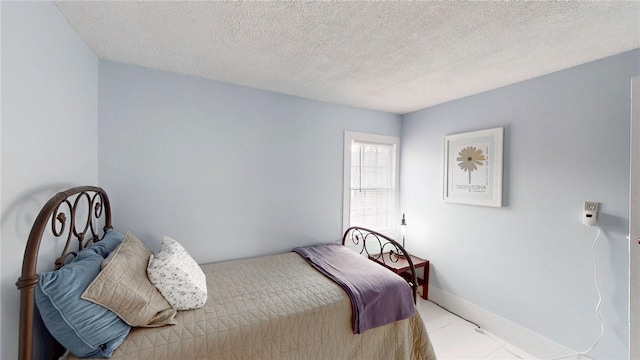 bedroom with baseboards and a textured ceiling