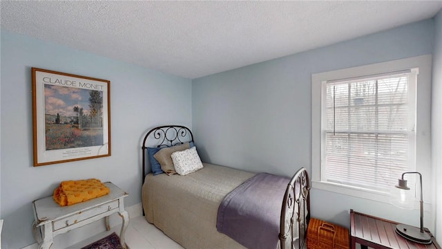 bedroom featuring a textured ceiling and light tile patterned flooring