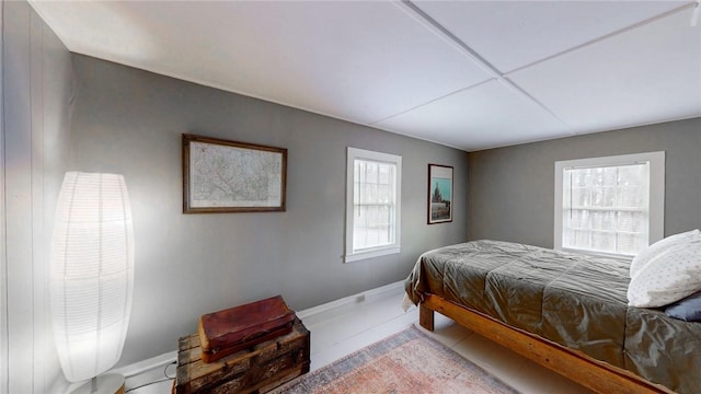 bedroom featuring baseboards and multiple windows