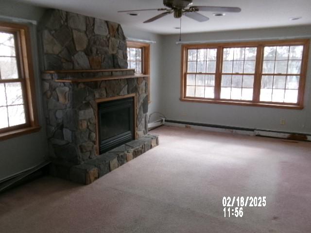 153 Holden Rd, Southport, NY 14871 - unfurnished living room with baseboard heating, a fireplace, a ceiling fan, and carpet