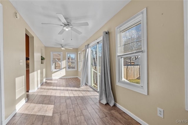 hallway featuring baseboards and wood finished floors