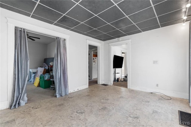 below grade area with a drop ceiling, baseboards, and visible vents