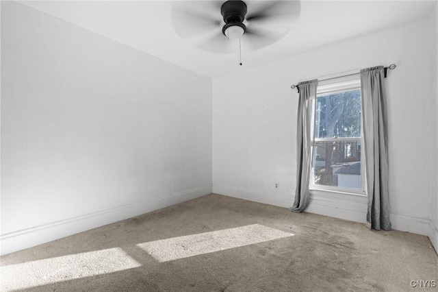 empty room with carpet flooring, baseboards, and ceiling fan