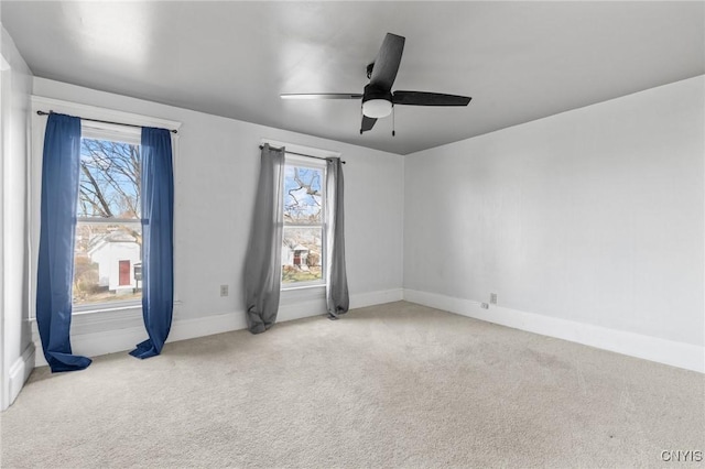 carpeted empty room with plenty of natural light, baseboards, and ceiling fan