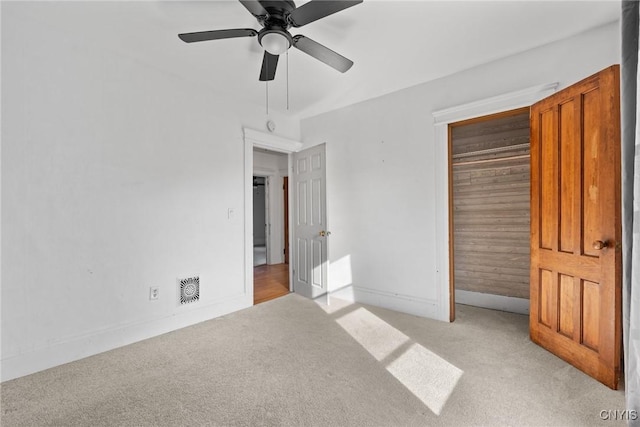 unfurnished bedroom with a ceiling fan, visible vents, baseboards, a closet, and light colored carpet