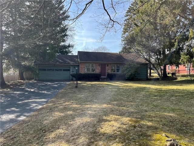 single story home featuring a garage, concrete driveway, a front yard, and fence