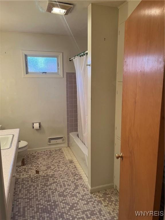 bathroom with vanity, baseboards, visible vents, shower / tub combo, and toilet