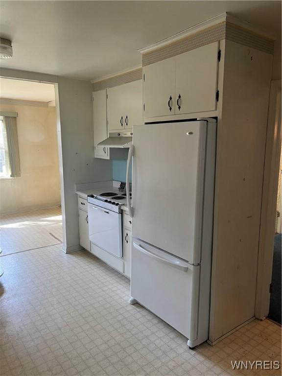 kitchen with under cabinet range hood, white cabinetry, white appliances, light countertops, and light floors