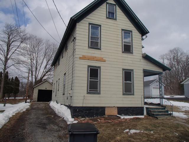 exterior space featuring an outbuilding, a detached garage, and aphalt driveway