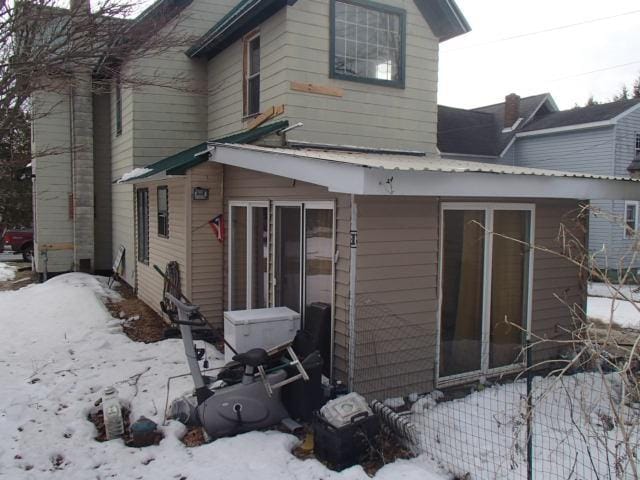 view of snow covered back of property