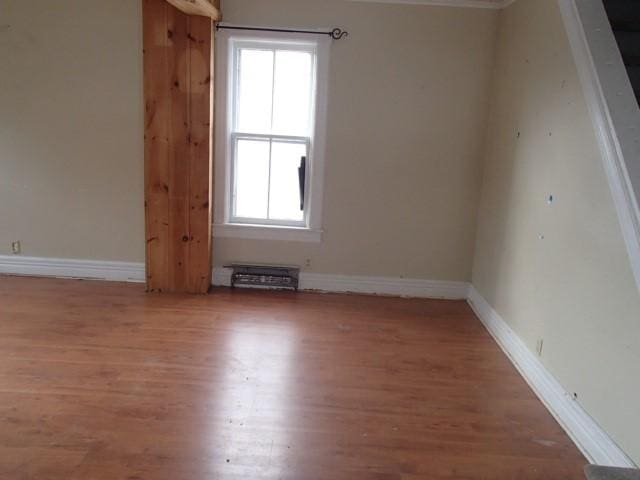 spare room featuring baseboards and wood finished floors