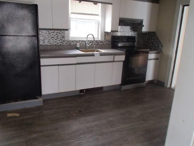 kitchen with range hood, white cabinetry, black appliances, and a sink