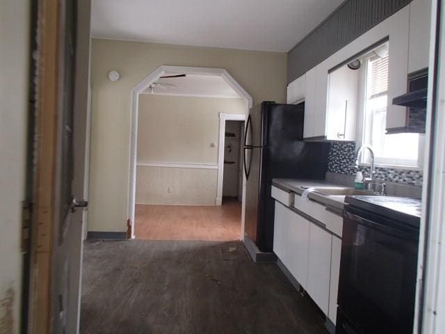 kitchen featuring dark wood-style flooring, a sink, decorative backsplash, white cabinets, and dishwasher