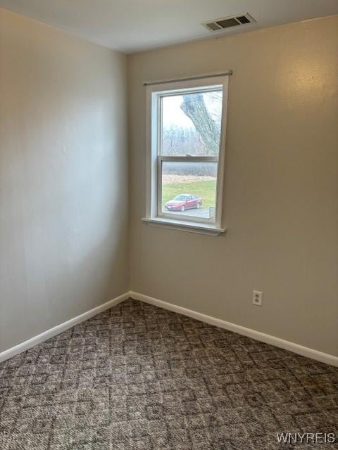 carpeted spare room with visible vents and baseboards