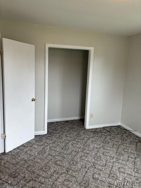 unfurnished bedroom featuring carpet flooring, baseboards, and a closet