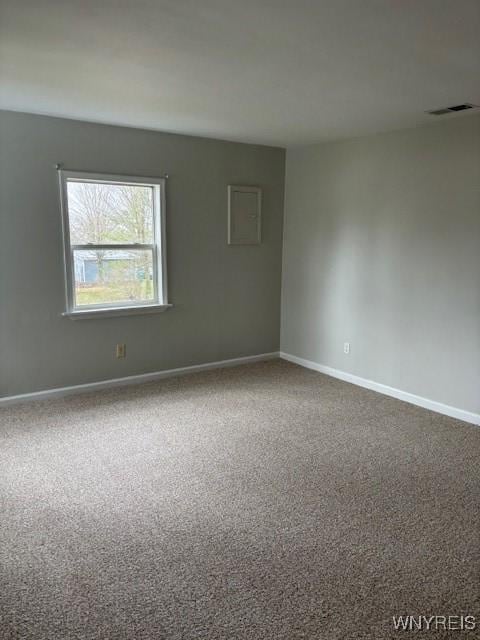 spare room with baseboards, visible vents, and dark carpet