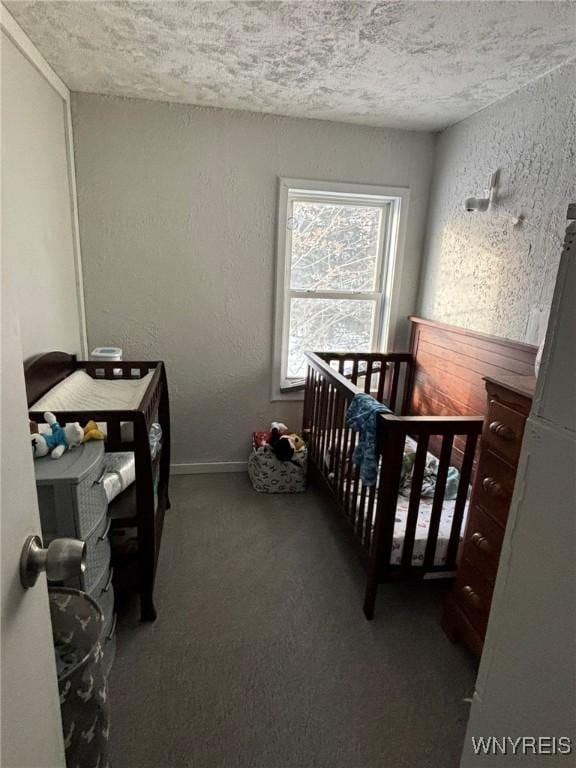 bedroom with baseboards, a textured ceiling, carpet, and a textured wall