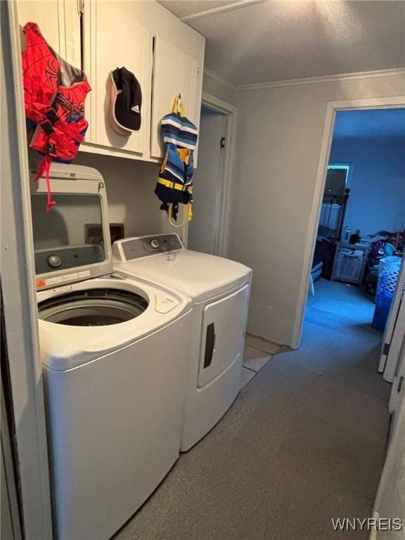 laundry area featuring washer and clothes dryer, cabinet space, and crown molding