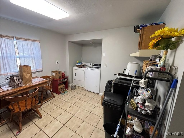 kitchen featuring light tile patterned floors, a textured ceiling, and washing machine and clothes dryer