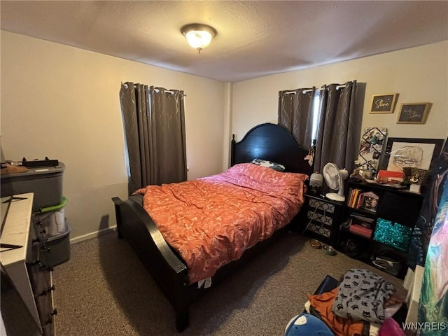 carpeted bedroom with a textured ceiling and baseboards