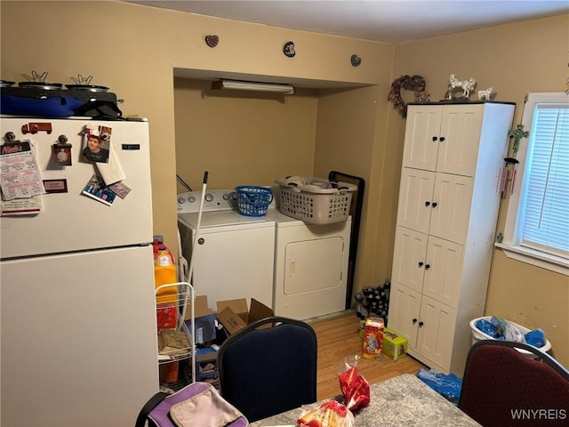 washroom with cabinet space, separate washer and dryer, and light wood-type flooring