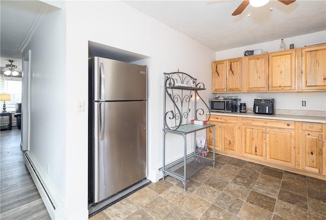 kitchen featuring a baseboard heating unit, appliances with stainless steel finishes, ceiling fan, and light countertops