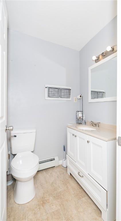 bathroom featuring baseboard heating, vanity, and toilet