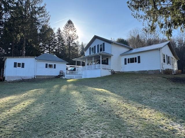 rear view of house featuring a yard