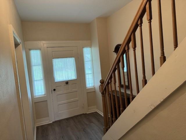 foyer entrance featuring stairs and wood finished floors